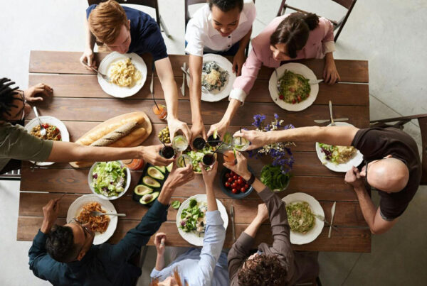 Digital Detox: Personas compartiendo una comida saludable alrededor de una mesa, brindando con entusiasmo